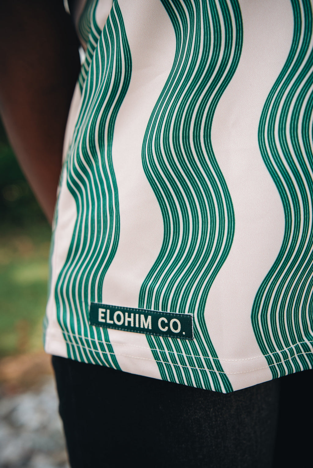 Heritage Jersey — front view showing Hebrew Elohim lettering on cream/green wave pattern