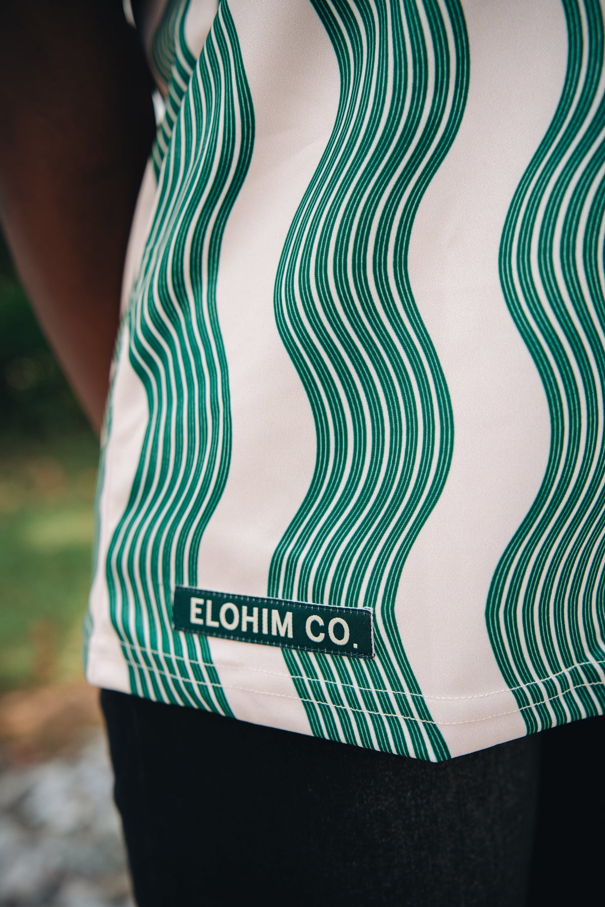Heritage Jersey — front view showing Hebrew Elohim lettering on cream/green wave pattern